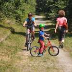 Voie verte Thiviers - Saint-Pardoux-la-Rivière. Enfant arrêté sur son vélo, un deuxième enfant se dirigeant vers lui sur son vélo tandis qu'une femme s'éloigne à pied.